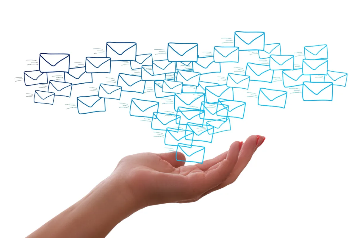 Mano abierta con un flujo de emails sobre ella